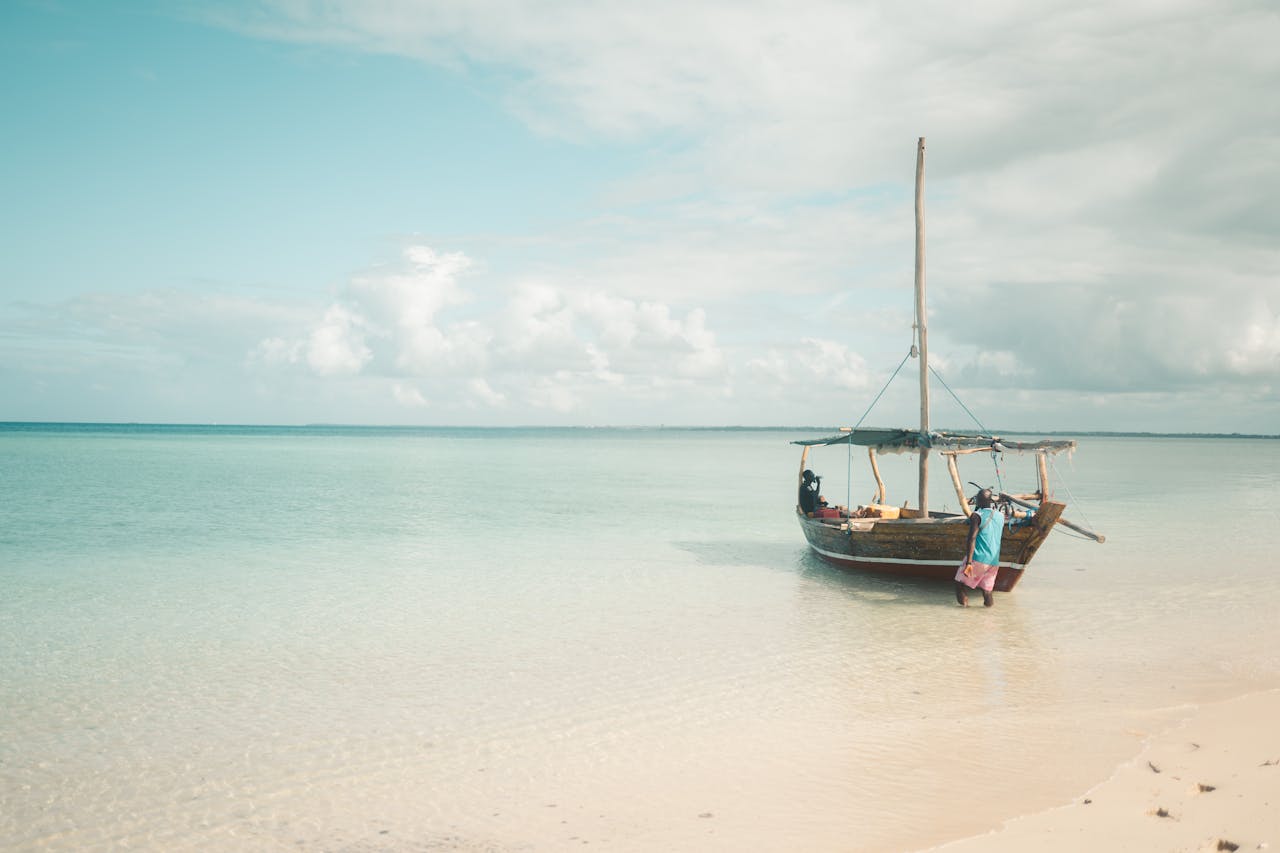 Scenic view of a traditional fishing boat on the clear turquoise waters of Zanzibar's coast, Tanzania.